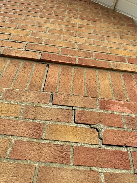 Diagonal crack running through red brick wall showing structural damage and settlement issues